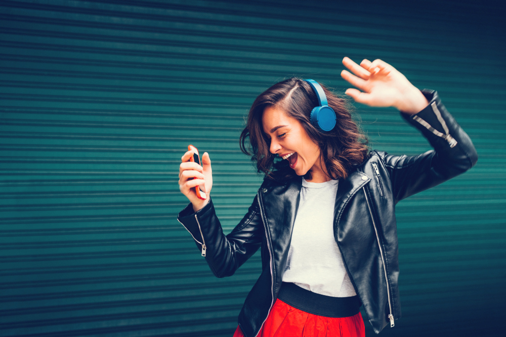 Jonge vrouw danst op muziek met koptelefoon op