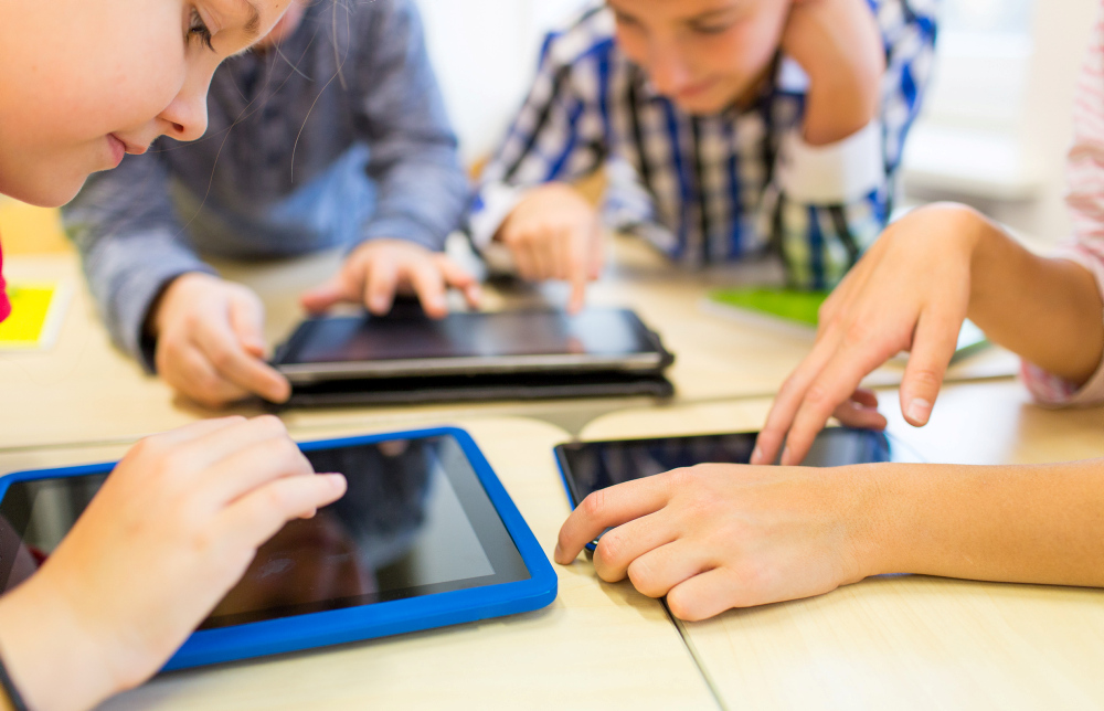 kinderen gebogen over beeldschermen van tablets